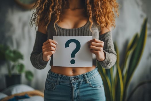 Woman holding question mark over her abdomen.