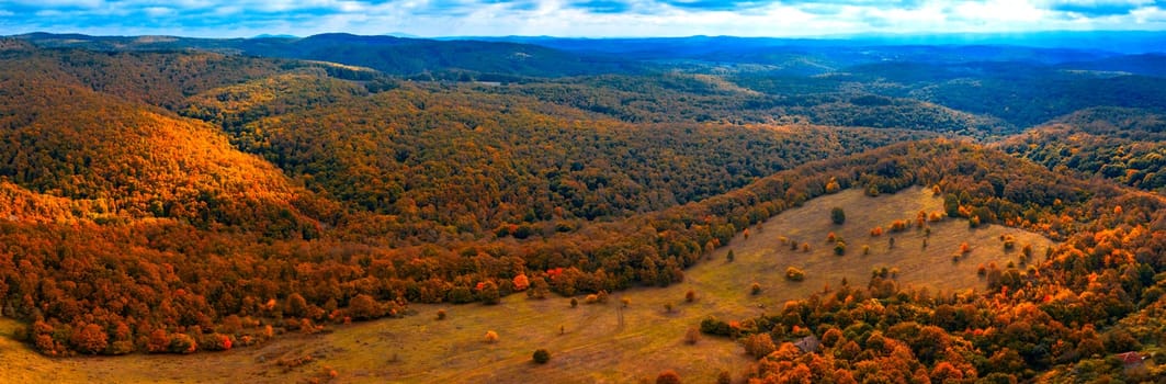 Panoramic aerial view of mountain peaks covered with autumn colors