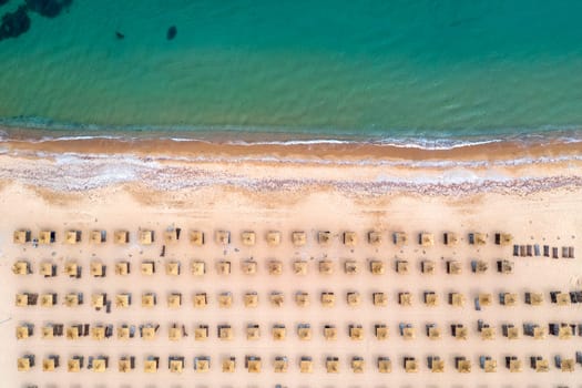 Aerial view of a fantastic beach with umbrellas, and a calm sea.