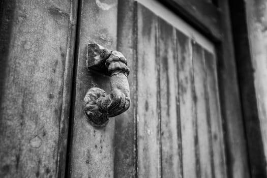 Door knocker. Old antique metal knocker on the wooden doors for knocking. Close up