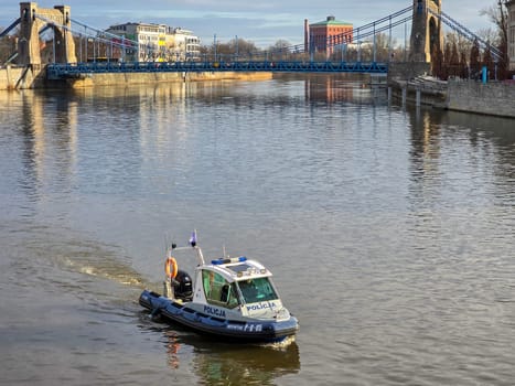 Wroclaw, Poland, February 15, 2024: Police patrol boat on the water surface, on the river in action at the Grunwaldzki Bridge in Wroclaw
