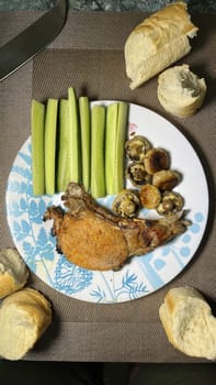 rib steak with cucumbers and mushrooms on a plate top view.