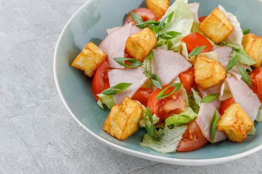 salad with ham and halloumi cheese on a stone background studio food photo 1