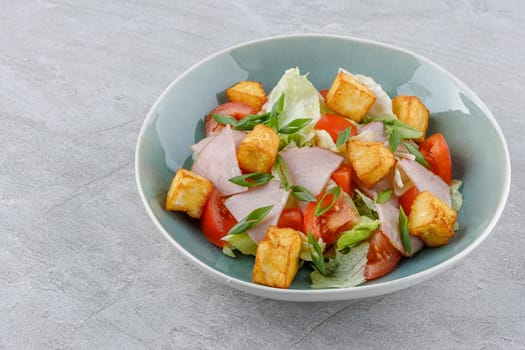 salad with ham and halloumi cheese on a stone background studio food photo