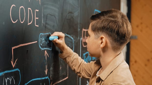 Panorama shot of smart boy writing engineering prompt on blackboard. Attractive student planing a project by using coding and programing system in STEM technology innovative class. Closeup. Erudition.