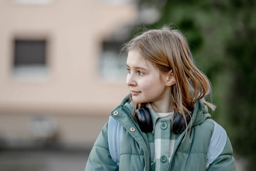 10-Year-Old Girl On A Spring Street, Portrait Of A Child With Headphones Around Her Neck