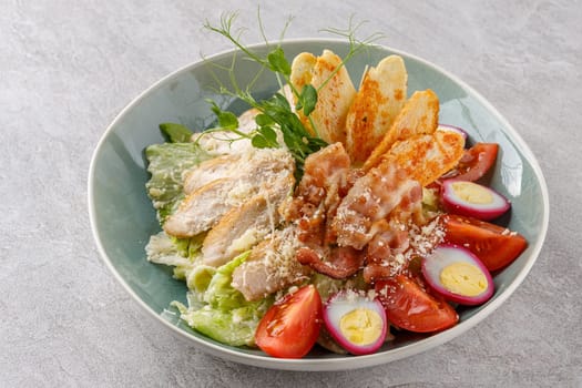 Caesar salad with chicken and bacon on a stone background studio food photo 4