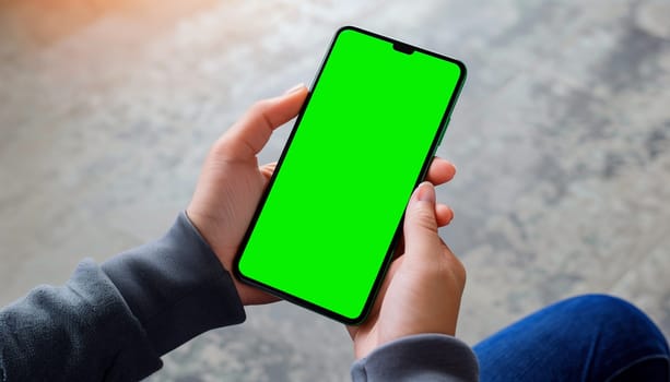 Mockup image of a business people holding smart mobile phone with blank green screen.