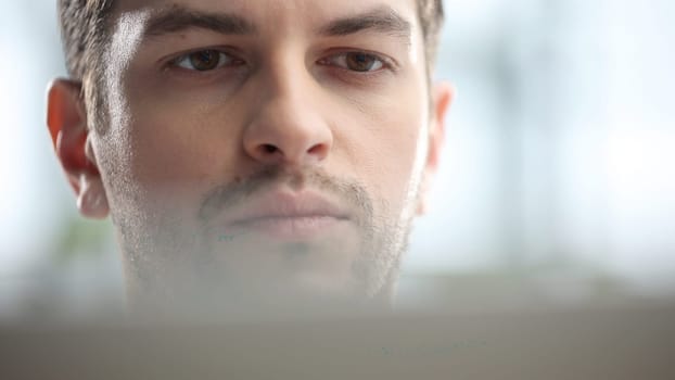 Male businessman in close-up working on a laptop.