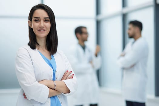 Confident female doctor posing in her office and smiling at camera, health care and prevention concept