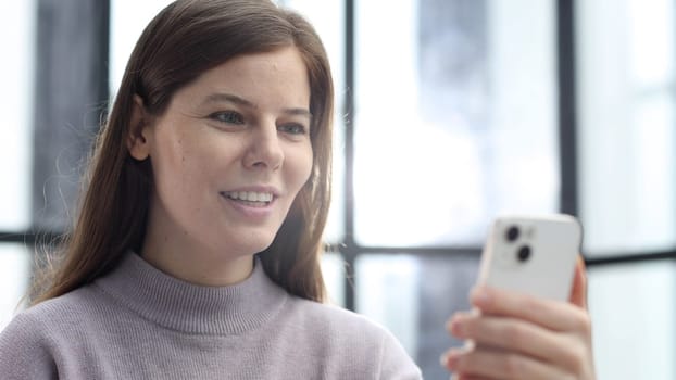 A woman's face is in close-up in the office, she is talking on the phone and discussing a deal.