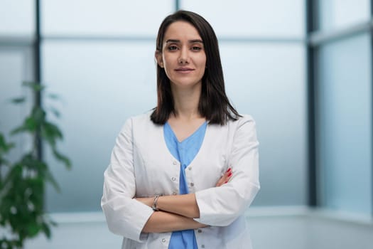 Confident female doctor posing in her office at camera