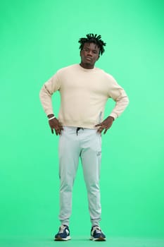 Man, full-length, on a green background, hands on his belt.