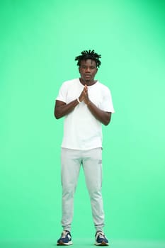 A man, full-length, on a green background, folded his arms.