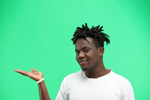 A man, close-up, on a green background, points to the side.