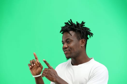 A man, close-up, on a green background, points to the side.
