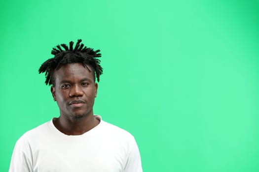 A man, close-up, on a green background.