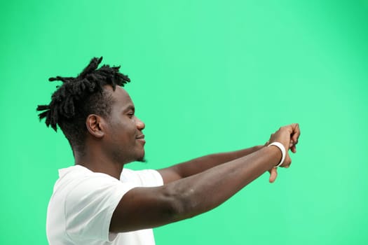 A man, close-up, on a green background, shows his thumbs down.