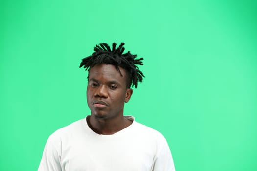 A man, close-up, on a green background.