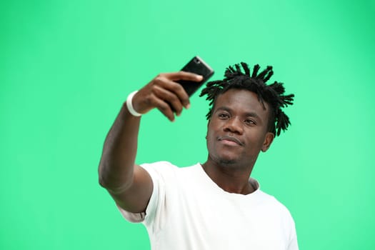 Man, close-up, on a green background, talking on the phone.