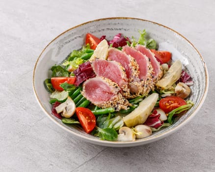 Tuna and artichoke salad on a stone background studio food photo