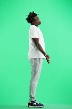 A man, full-length, on a green background, spreads his arms.