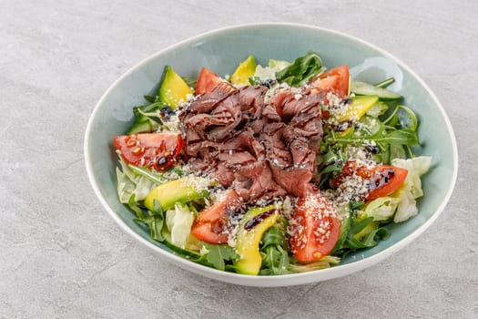 Salad with roast beef, avocado and tomatoes on a stone background studio food photo 1