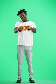 A man, full-length, on a green background, with a gift.