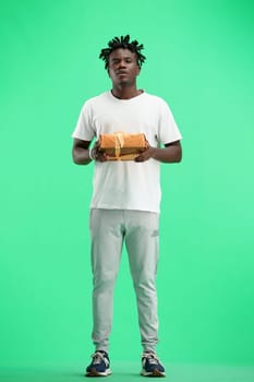 A man, full-length, on a green background, with a gift.