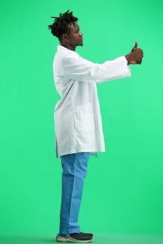 The doctor, in full height, on a green background, shows a thumbs up.