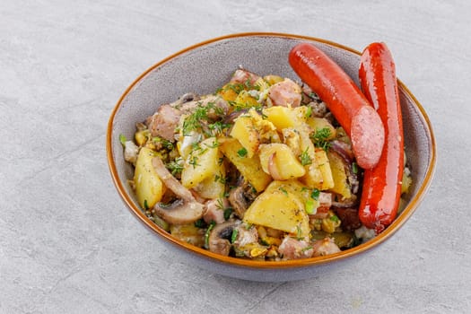 fried potatoes with mushrooms and sausages on a stone background studio food photo 3