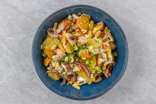 fried potatoes with mushrooms and ham on a stone background studio food photo 3