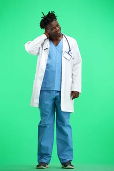 The doctor, in full height, on a green background, tired.