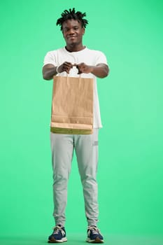 A man, full-length, on a green background, with bags.