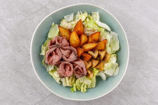 Salad with roast beef and potatoes on a stone background, studio food photo 2