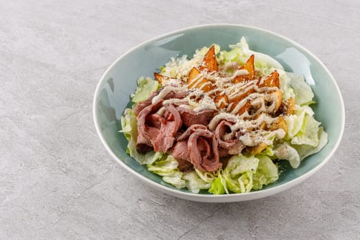 Salad with roast beef and potatoes on a stone background, studio food photo 1