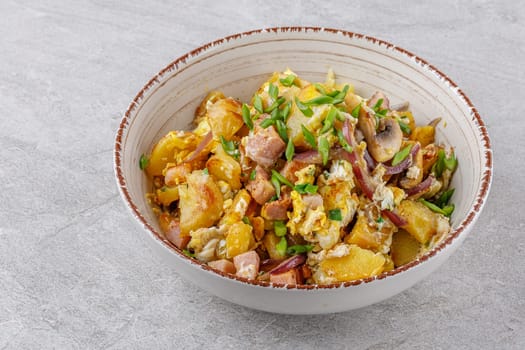 fried potatoes with mushrooms and ham on a stone background studio food photo 1