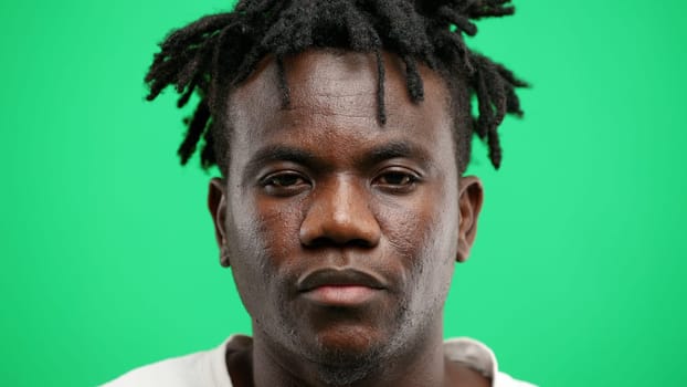 Man's face, close-up, on a green background.