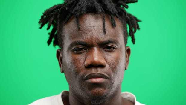 Man's face, close-up, on a green background.