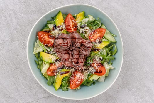 Salad with roast beef, avocado and tomatoes on a stone background studio food photo 2