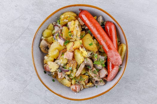 fried potatoes with mushrooms and sausages on a stone background studio food photo 1
