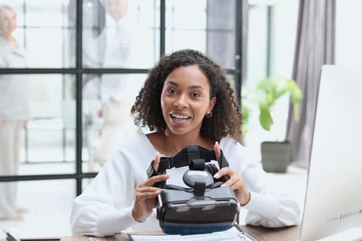 woman testing VR glasses or goggles sitting in the office room