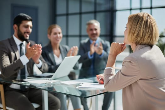 female boss gives instruction to her subordinates in a modern office