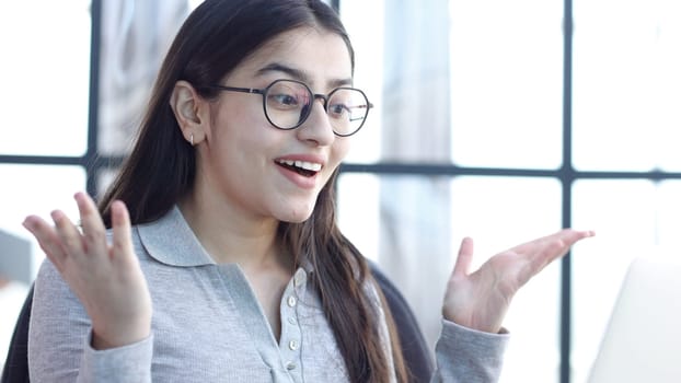 A young woman in the office is surprised in close-up.