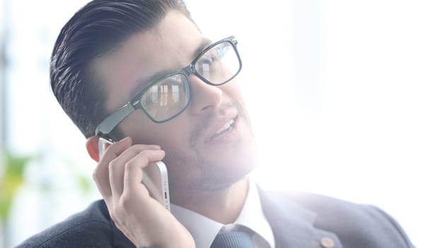 A male businessman is talking on the phone in close-up.