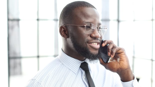 The face of a businessman man in close-up he is talking on the phone in the office.