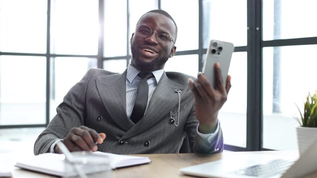 A businessman man in a close-up in a jacket, he is talking on the phone in the office.
