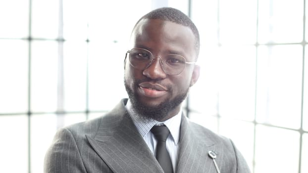 The face of a businessman man in a jacket is a close-up in the office, he looks at the camera.
