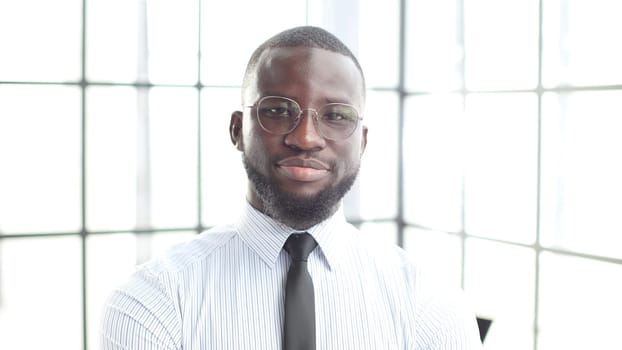 The face of a businessman man in a shirt is a close-up in the office, he looks at the camera.
