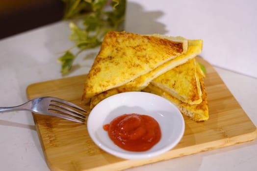 Fresh fried delicious french toast sandwich with cheese filling plated in white plate, just freshly fried in the restaurant